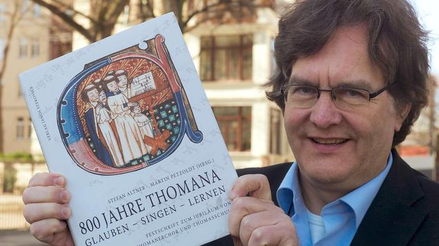 Georg Christoph Biller, der 16. Kantor des Thomanerchores nach Johann Sebabestian Bach, mit der Festschrift zum 800-jährigen Bestehen des Thomanerchores. - FOTO: PETER ENDIG DPA/LSN 